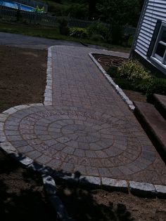 a brick walkway in front of a house