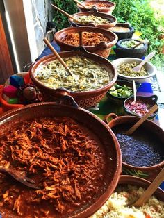 a table filled with lots of different types of food on top of plates and serving utensils