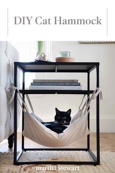 a black cat laying in a hammock on top of a table