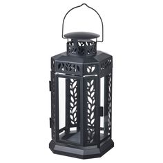 a black lantern with an intricate design on the top and bottom, sitting against a white background