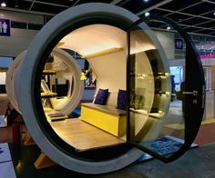 a room with a couch inside of it and a large circular window in the middle