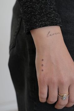 a person with a small tattoo on their left wrist and the word love written in cursive writing