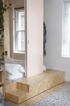 a room with some stairs and a bed in the corner next to a book shelf