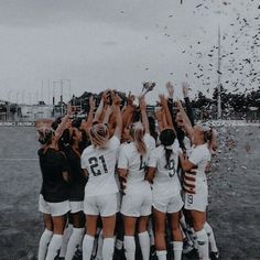 a group of women's soccer players celebrating with confetti in the air