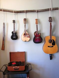 guitars are hanging on the wall in a room