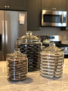 three glass jars sitting on top of a counter