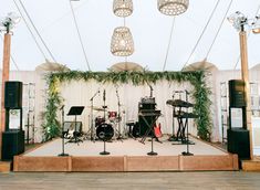 a stage set up with musical instruments and lights for an outdoor wedding or event venue