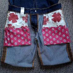 a pair of blue jeans with red and white flowers on them