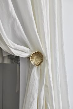 a white curtain with a gold scallop on it