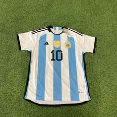 a blue and white soccer jersey laying on the ground