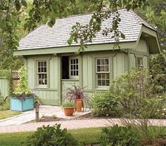 a small green house sitting in the middle of a yard