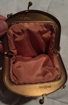 someone is holding an open purse with gold trimmings on the bottom and inside