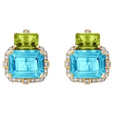 Introducing the captivating 2 Stone Peridot and Blue Topaz Emerald Cut Earrings with Diamonds in 18K Yellow Gold, a remarkable creation from the exquisite 'Gossip' Collection. Crafted with meticulous attention to detail, these earrings embody elegance and sophistication, making them a perfect accessory for any glamorous affair. Encircling the mesmerizing Blue Topaz stone is a halo of dazzling diamonds. Carefully selected for their exceptional quality and brilliant sparkle. Set in 18K yellow gold, the warm and lustrous metal enhances the rich colors of the gemstones, creating a harmonious union of elegance and beauty. The design of these earrings is both timeless and contemporary. The emerald-cut gemstones exude a classic charm, while the arrangement of the stones in a two-stone setting add Emerald Cut Earrings, Diamonds Earrings, Cut Earrings, Blue Topaz Stone, Topaz Stone, Stone Settings, Modern Jewelry, Emerald Cut, Jewelry Earrings Studs