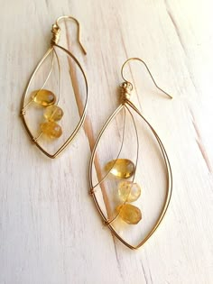 A mix of tiny citrine stones float across a delicate leaf of 14k gold filled wire.Size is a little over 2 inches.MATERIAL:GOLD-FILLED - 14k Gold filled is considerably durable and considered a lifetime piece of jewelry. This is NOT gold plated or gold dipped vermeil jewelry which can chip off over time with wear. Gold filled metal is essentially a 14k gold tube filled with an inner core metal such as brass and has been mechanically bonded with high very hot heat. It will never chip or flake off Cheap Wire Wrapped Small Hoop Earrings, Wire Jewelry Earrings Set, Simple Wire Earrings Rustica Jewelry, Dainty Earrings With Ear Wire, Cheap Small Wire Wrapped Hoop Earrings, Epoxy And Wire Jewelry, Cheap Dainty Earrings With Ear Wire, Beads And Wire Earrings, Handcrafted Jewelry Wire