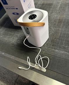 an air conditioner sitting on top of a metal table next to a cardboard box