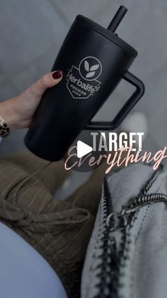 a woman holding a black coffee cup with the words target everything on it