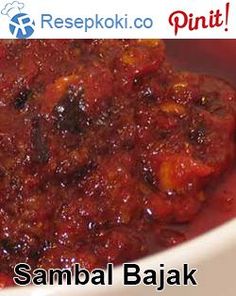 a bowl filled with food sitting on top of a white table next to a sign that reads, sambal bajak