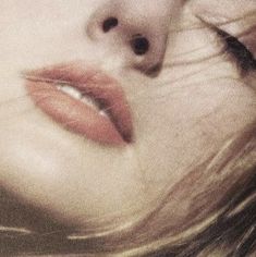 a close up of a woman's face with red lipstick on her lips and nose