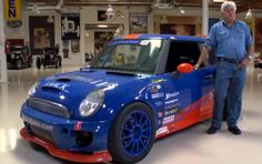 a man standing next to a blue and red car