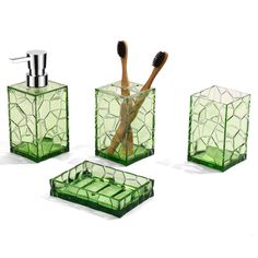 three green glass containers with toothbrushes and soap dispenser