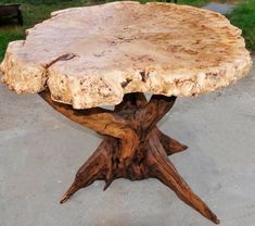 a large wooden table sitting on top of a cement ground