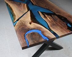 a table made out of wood with blue paint on the top and black metal legs