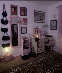 a bedroom decorated in pink and black with pictures on the wall, leopard print rugs