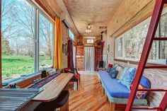 a living room filled with furniture next to a wooden floor and window covered in curtains