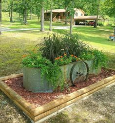 an old wagon is used as a planter for flowers and plants in the yard