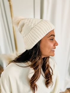 This beanie is a timeless classic with its ivory coloring and ivory pom, as well as its cable texture. Keep warm in this classic style while looking fashionable. Cream Soft Knit Beanie, Cozy Cream Knit Hats, Cozy Cream Beanie For Fall, Cozy Cream Soft Knit Hat, Cream Soft Knit Beanie Hat, Cream Soft Knit Winter Hat, Cream Beanie For Cold Weather In Fall, Cream Soft Knit Beanie For Cold Weather, Cozy Warm Cream Beanie