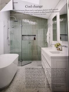 a bathroom with green tile and white fixtures on the walls, along with a bathtub