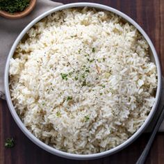 a white bowl filled with rice on top of a wooden table