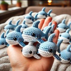 hand holding small crocheted blue and white shark figurines