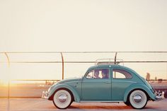 an old blue car is parked on the street