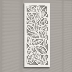 an intricate laser cut paper panel with leaves on the front and back, in white