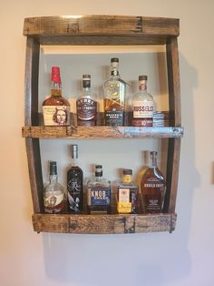 an old wooden shelf with liquor bottles on it