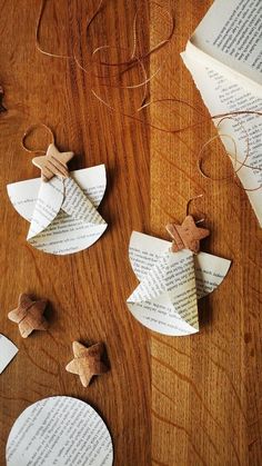 folded paper stars on top of an open book with string and twine attached to them