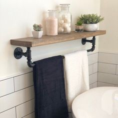 a bathroom shelf with towels and plants on it