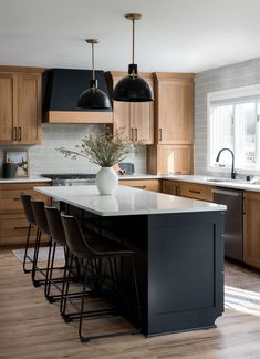 a kitchen with wooden cabinets and white counter tops next to an island in the middle