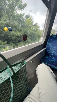 an empty seat on a train next to a window with trees in the back ground