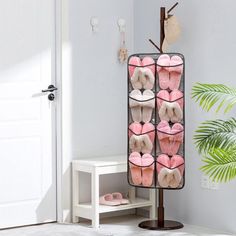 a rack with several pairs of pink slippers hanging from it's sides in front of a door