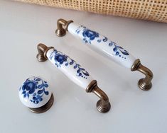 three handles and knobs with blue flowers on them