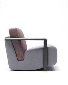 a grey chair with a pink pillow on it's back and armrests