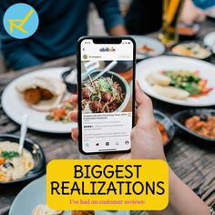 a person holding up a cell phone to take a photo of food on the table