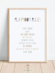 the playroom rules print is displayed in front of a white wall and wooden floor