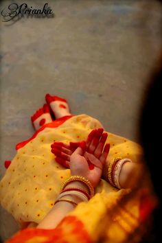 a woman holding a baby with red paint on it's hands and feet in the air