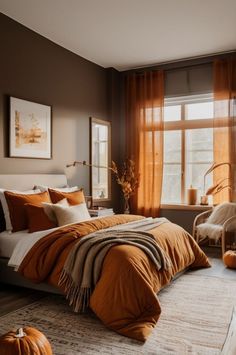 a bed room with a neatly made bed and two pumpkins