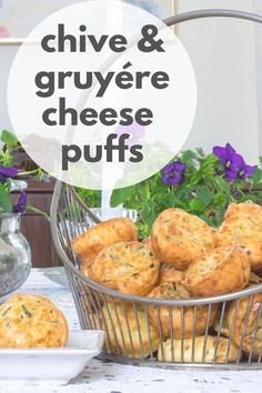 a basket filled with cheese muffins sitting on top of a table next to flowers