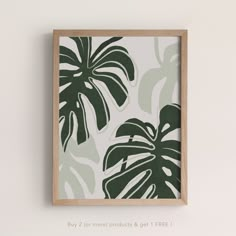 a green and white wall hanging on the side of a wall with a plant print