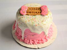 a birthday cake decorated with sprinkles and donuts on the top layer